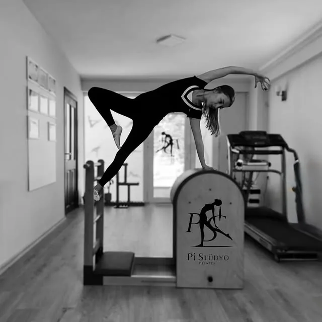 Eğitmen Pınar Sarı Koçak, Çorum'daki Pi Stüdyo Pilates'te pilates chair üzerinde yana eğilme egzersizi yapıyor (siyah-beyaz)